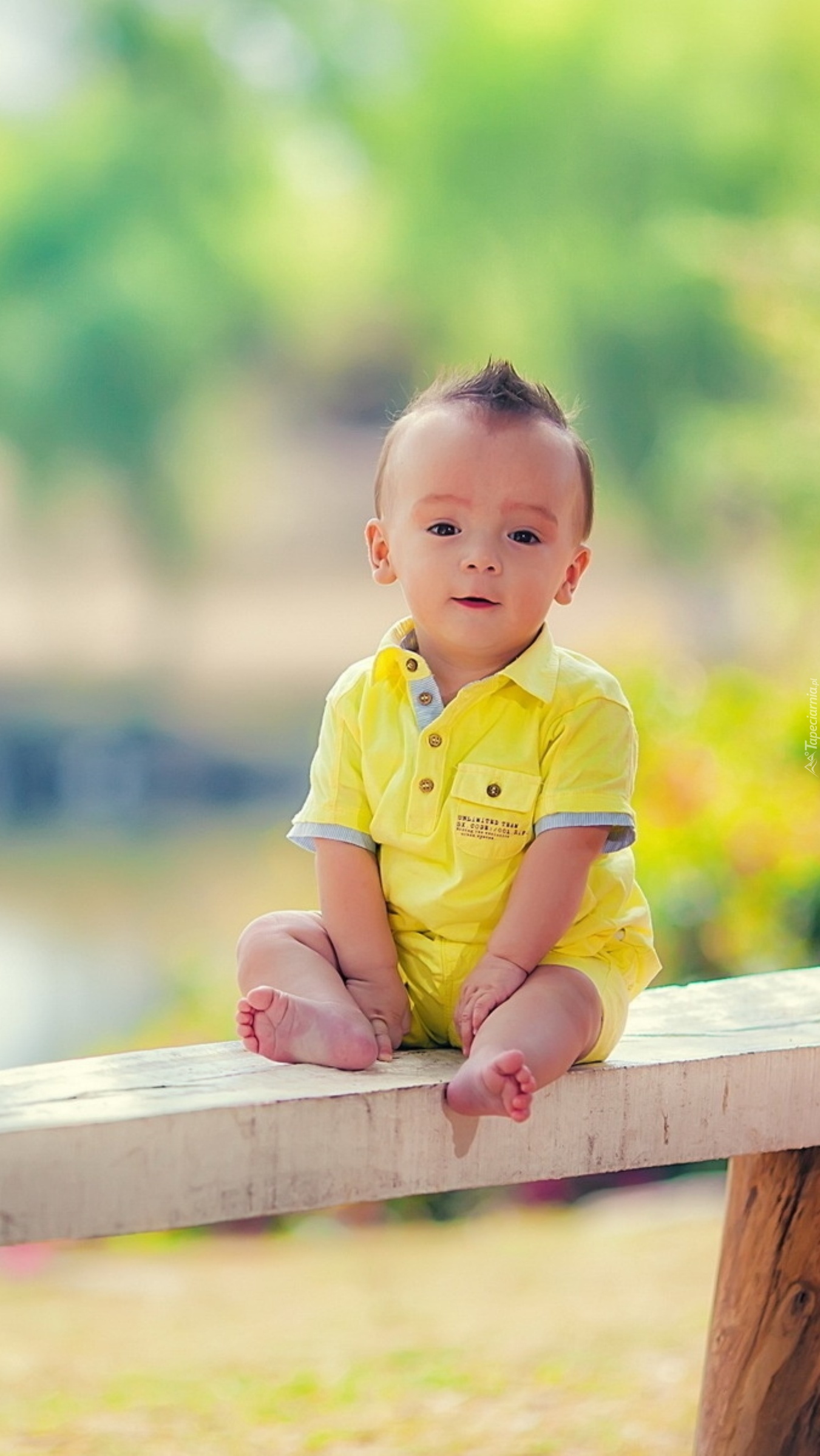 Chłopiec w żółtym ubranku na ławce