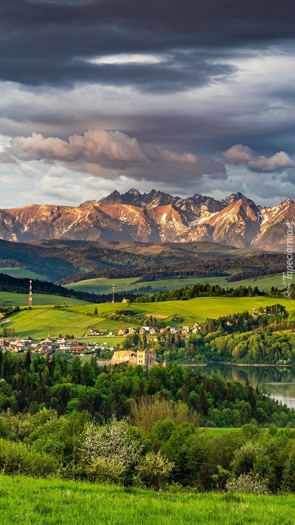 Ciemne chmury nad górami i domami nad jeziorem