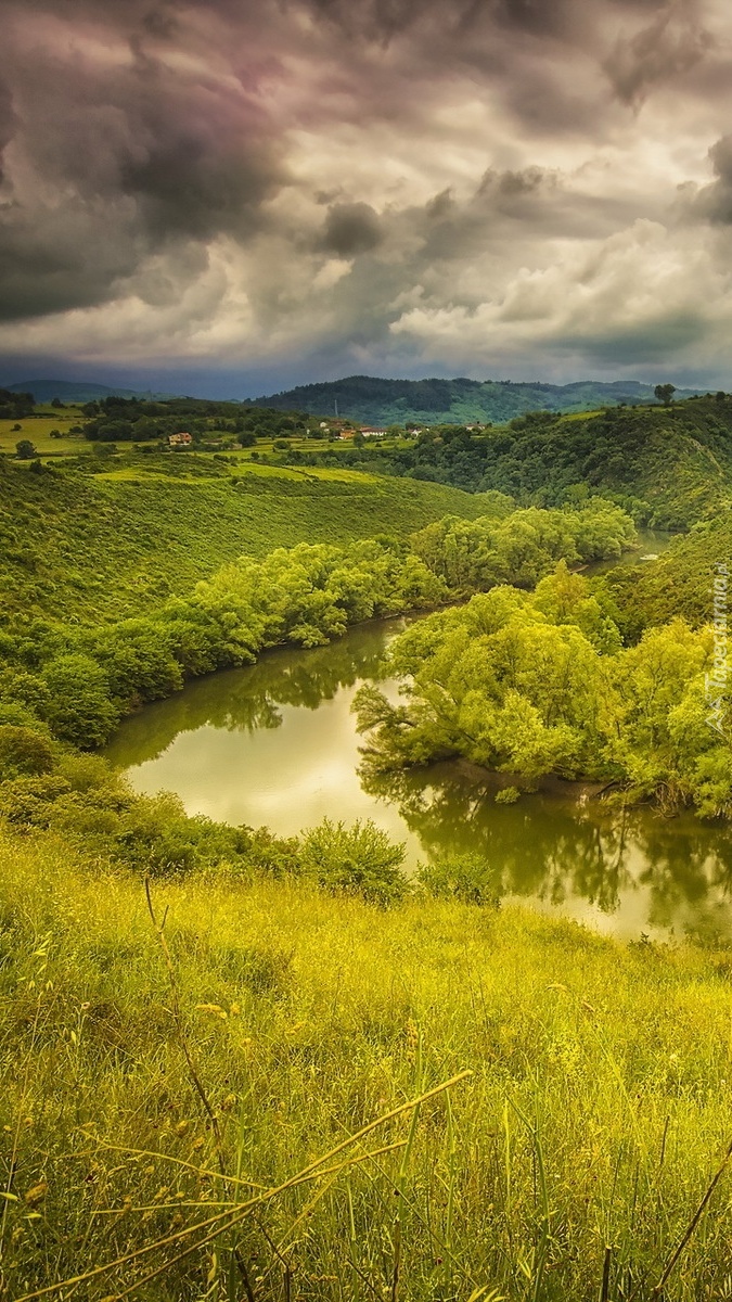 Ciemne chmury nad lasem i rzeką