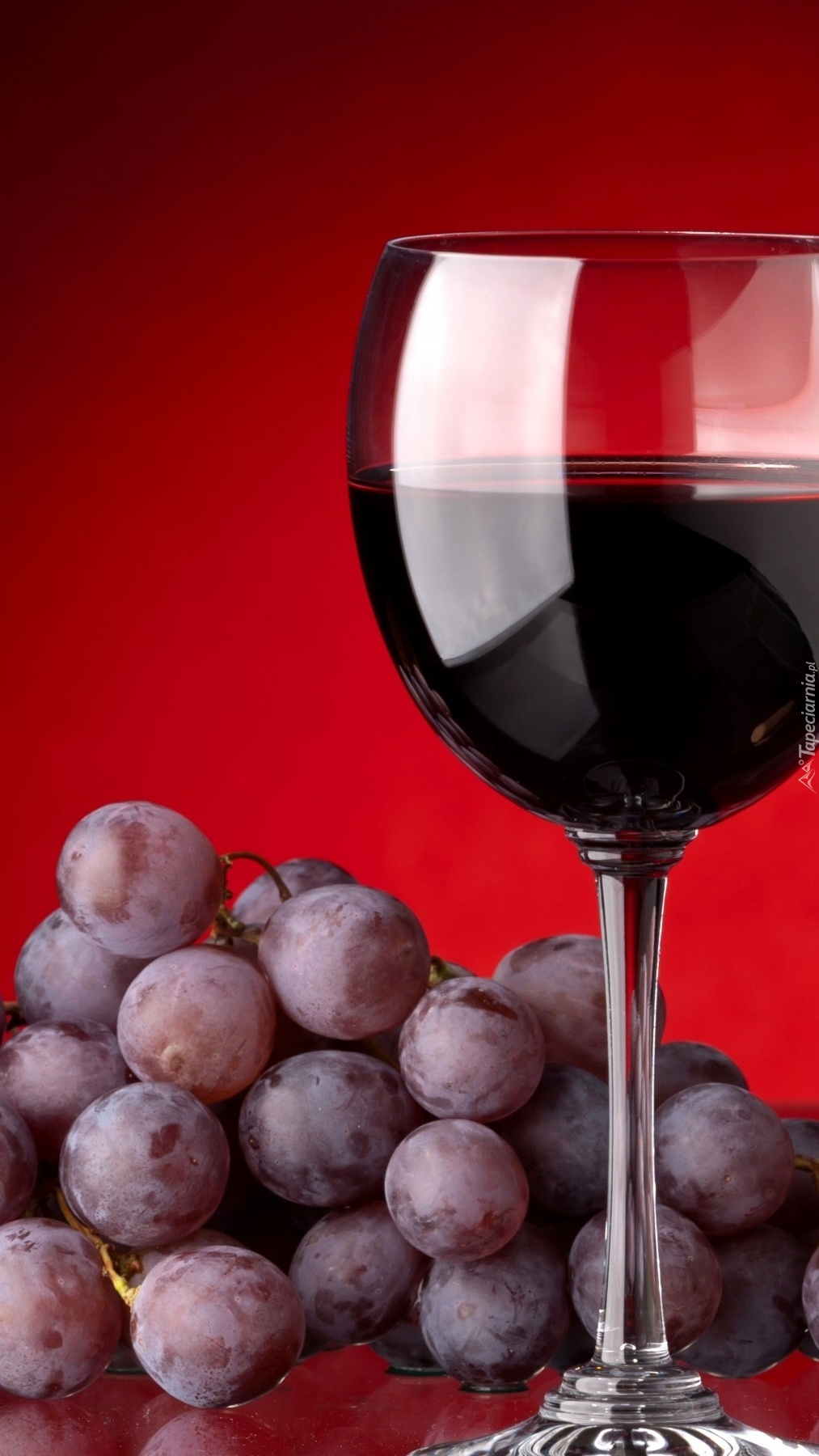Czerwone wino obok winogron