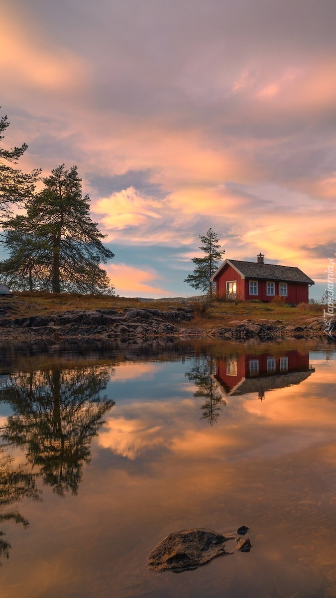 Czerwony domek nad norweskim jeziorem Vaeleren