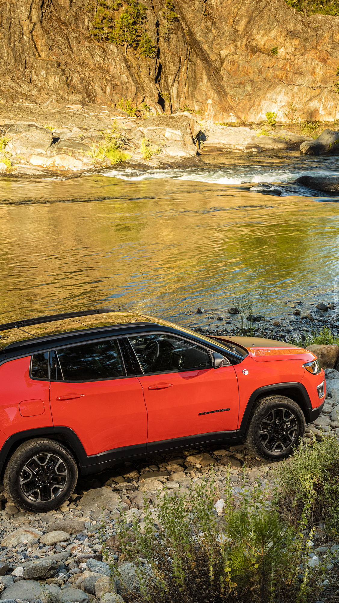 Czerwony Jeep Compass na brzegu rzeki