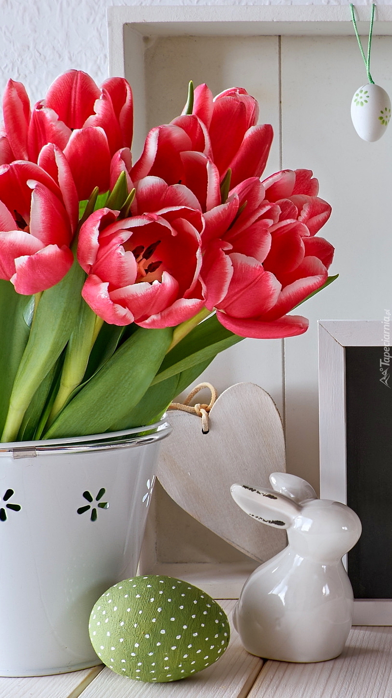 Dekoracja wielkanocna obok wazonu z tulipanami