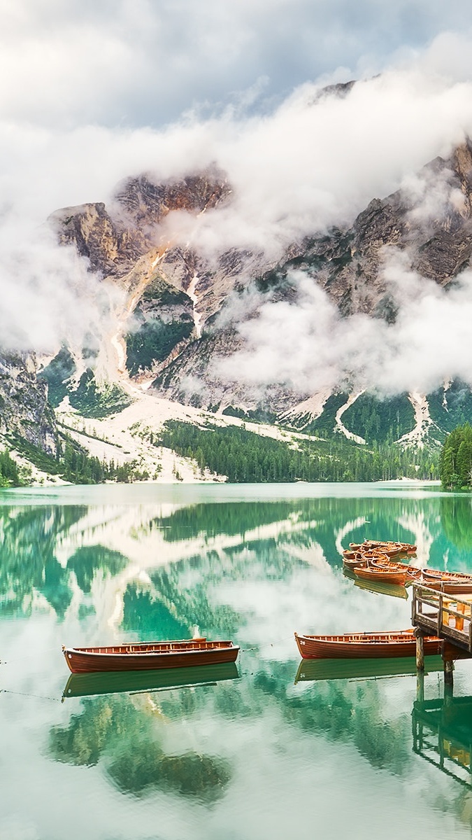 Dolomity we mgle i łódki na jeziorze Pragser Wildsee