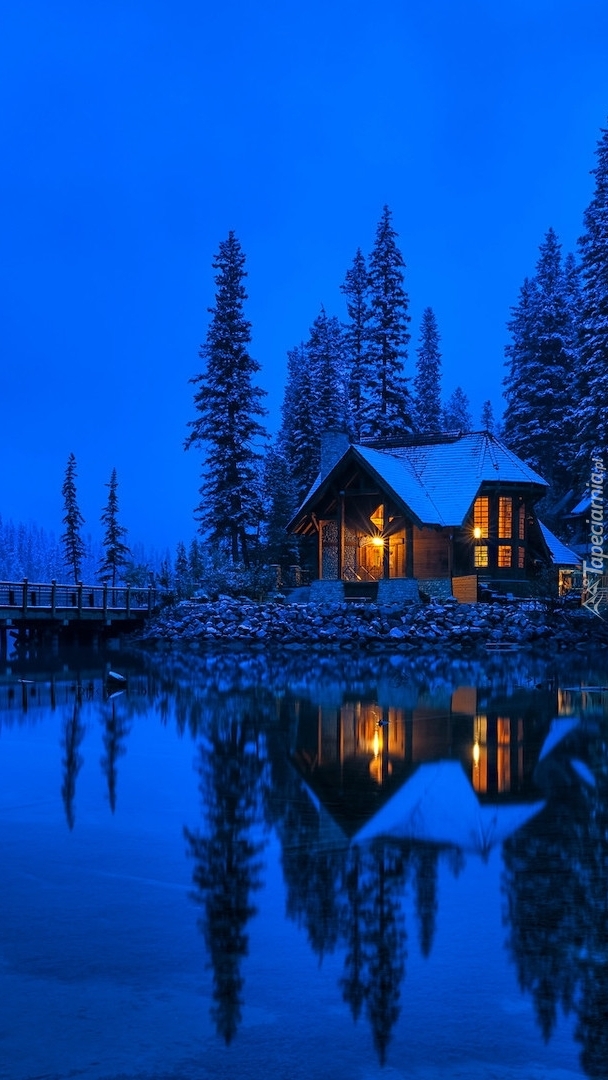 Dom na brzegu jeziora Emerald Lake nocą
