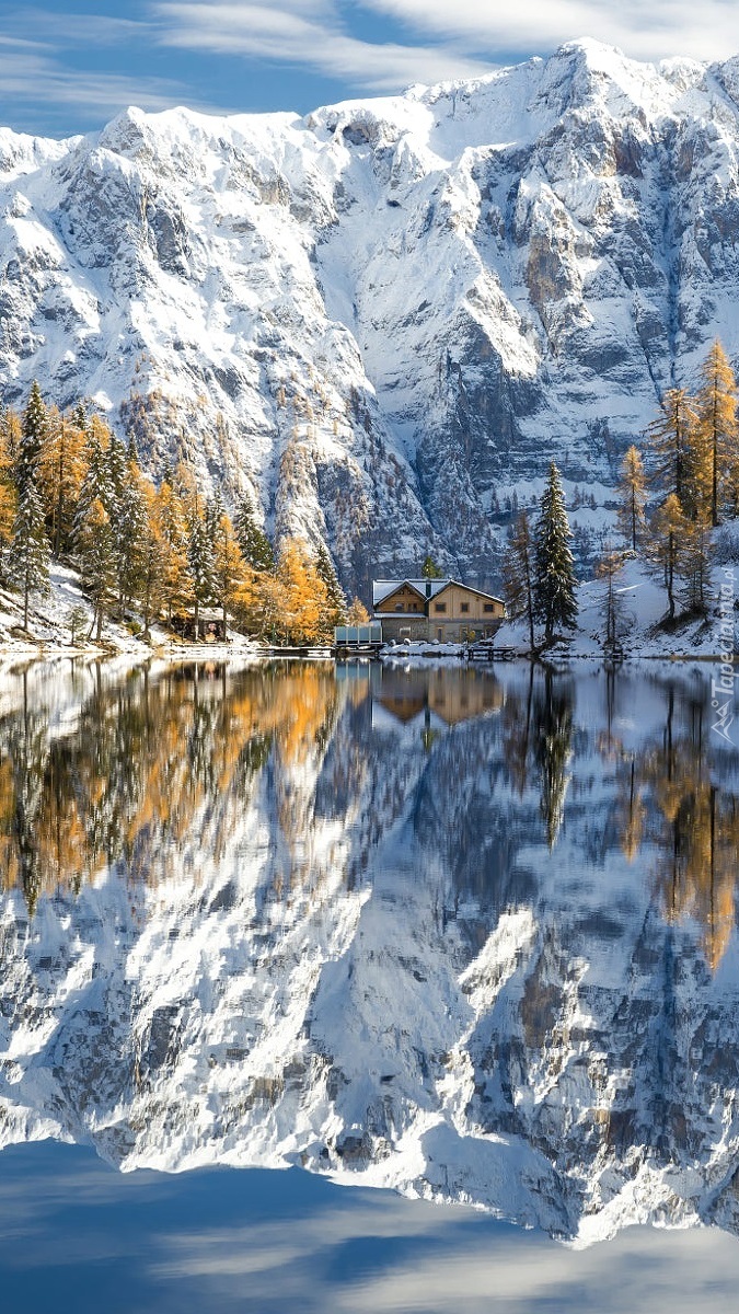 Dom nad jeziorem Lake Malghette pod ośnieżonymi górami