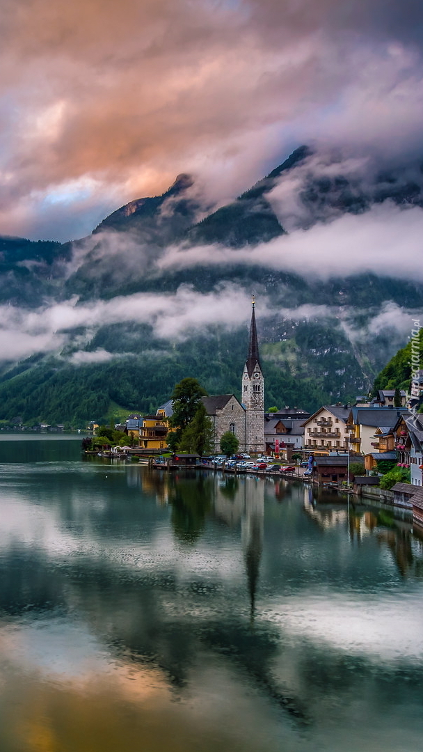 Domy i zamglone góry nad jeziorem Hallstattersee