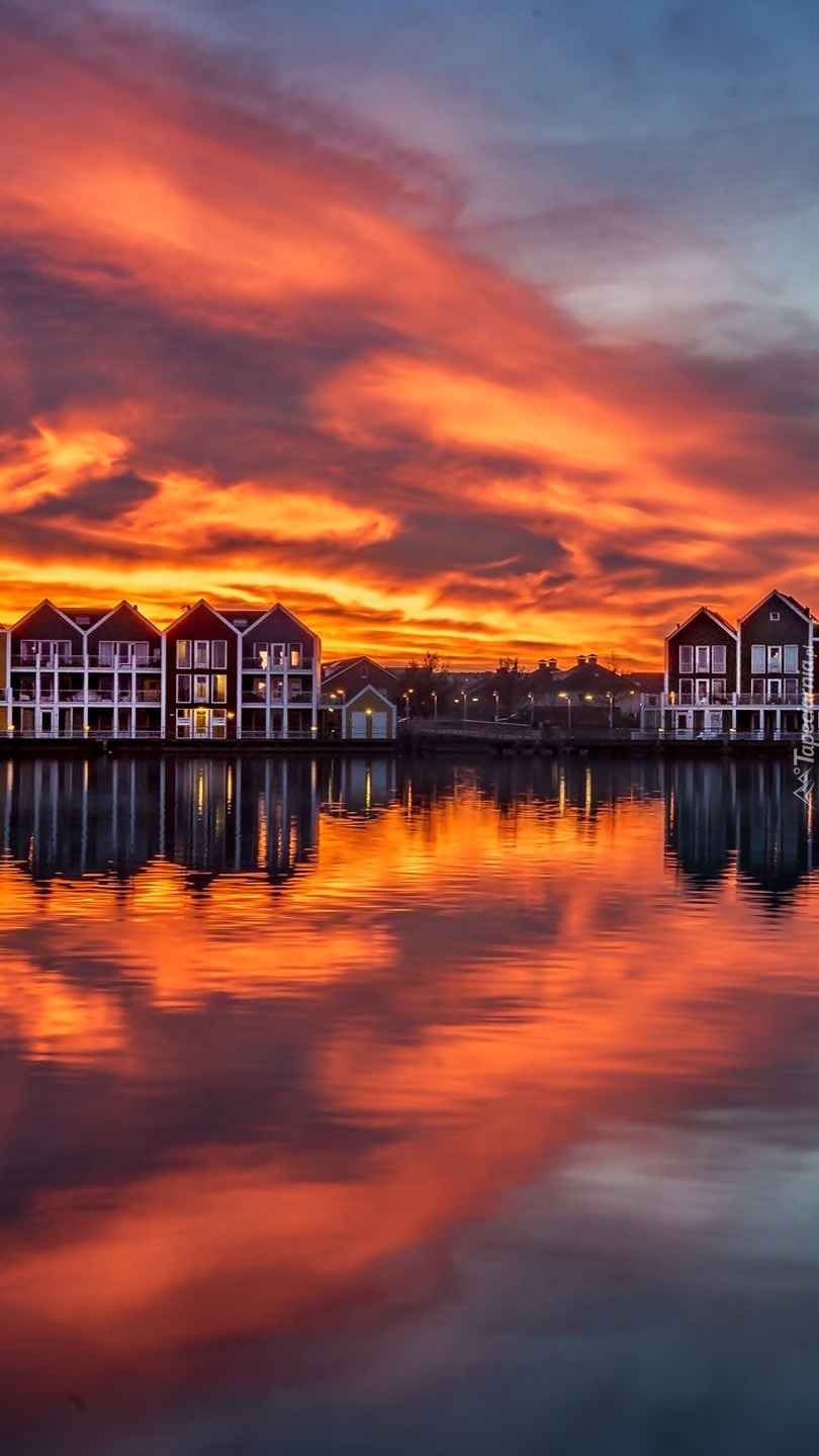 Domy nad jeziorem Rietplas w Holandii o zachodzie słońca