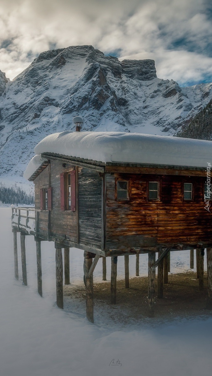 Drewniany dom na palikach w górach zimą