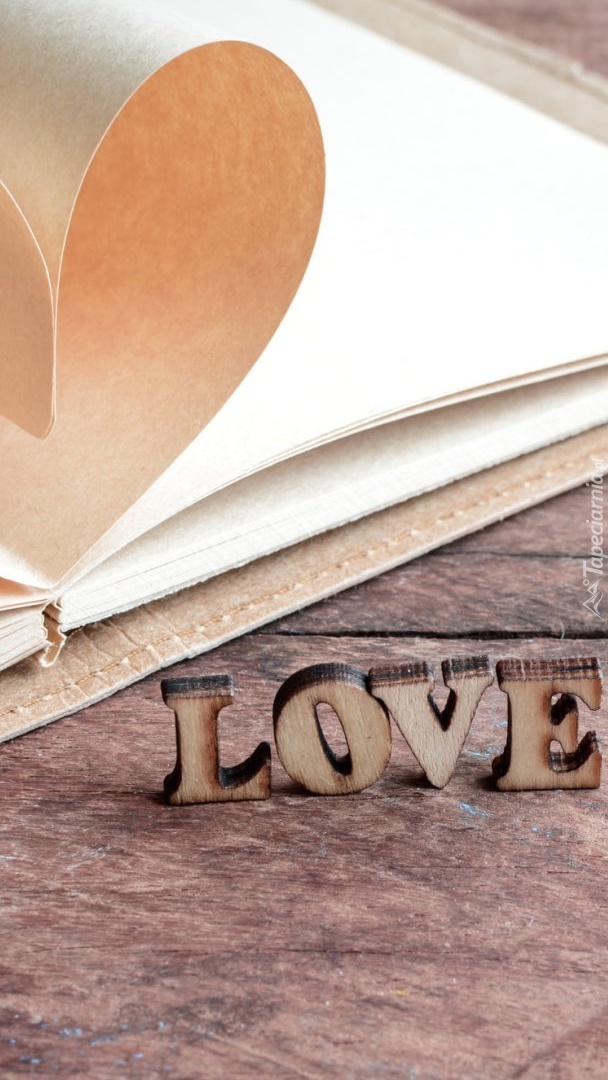 Drewniany napis Love obok zeszytu