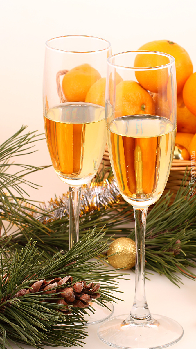 Dwa kieliszki szampana z mandarynkami w tle
