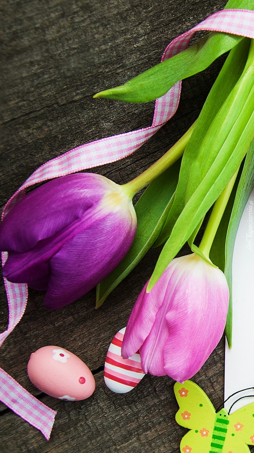 Dwa tulipany obok pisanek i motylka