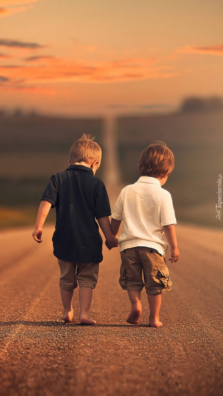 Dwóch małych chłopców idących drogą