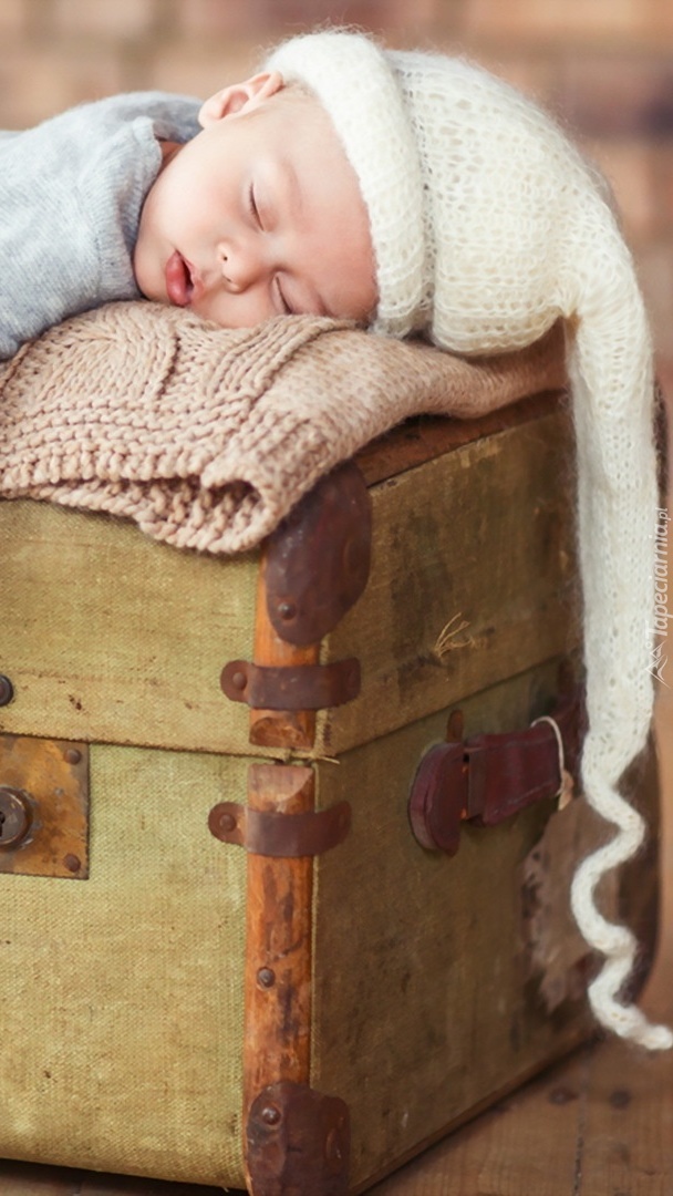 Dziecko śpiące na kufrze