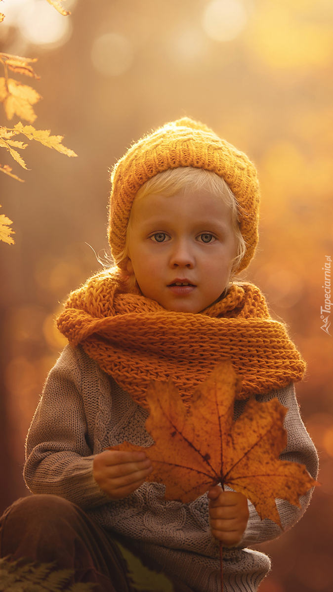 Dziecko z jesiennym liściem w ręce