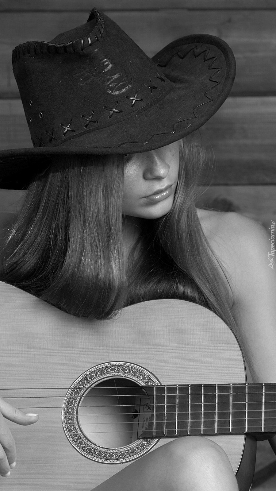 Dziewczyna w kapeluszu grająca na gitarze