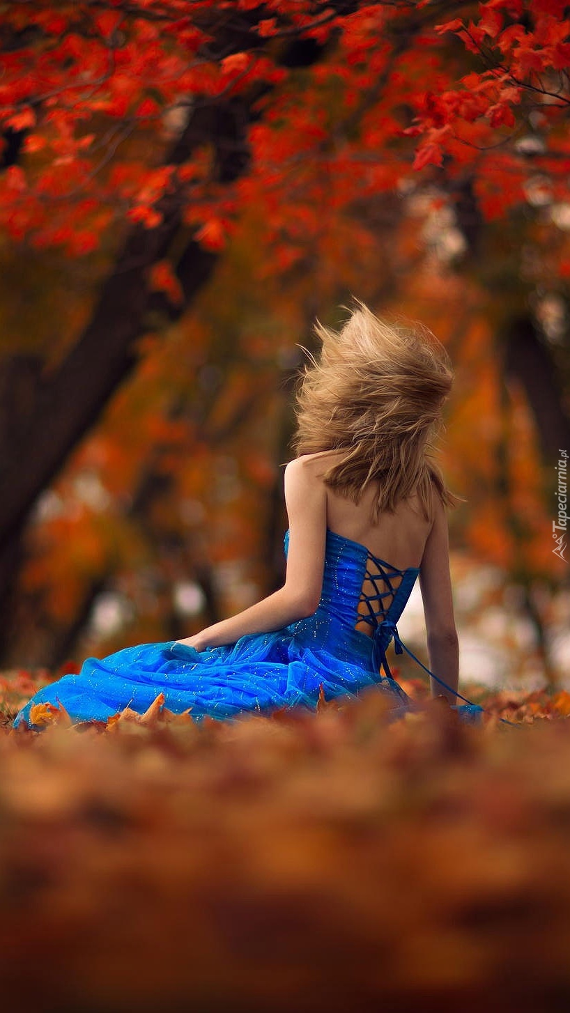 Dziewczyna w niebieskiej sukience w jesiennym parku