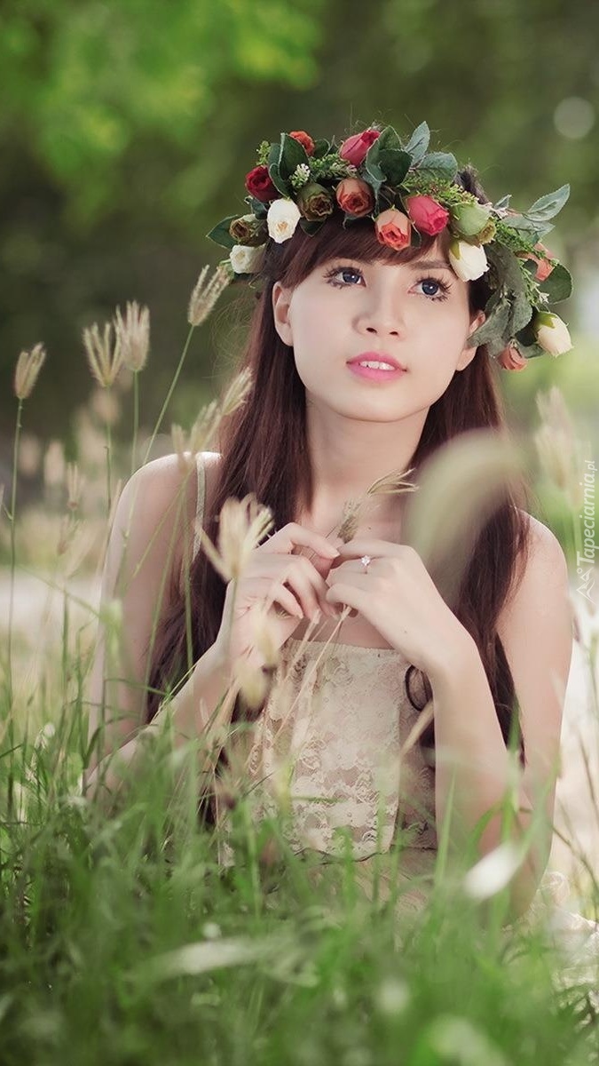 Dziewczyna w różanym wianku w wysokiej trawie