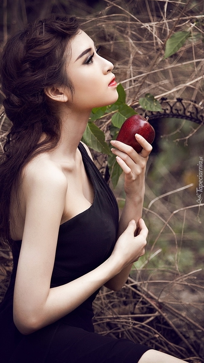 Dziewczyna z jabłkiem przed lustrem