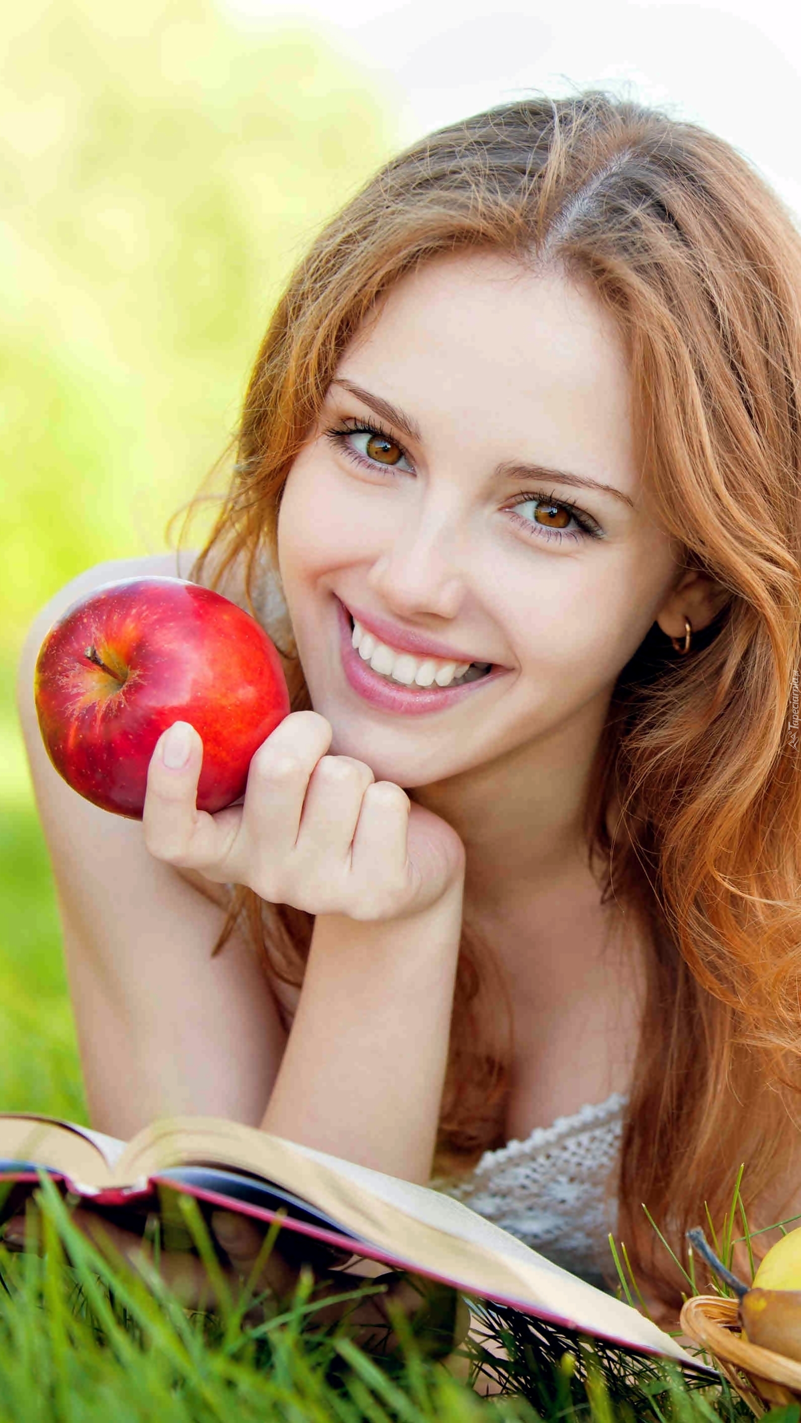 Dziewczyna z książką i jabłkiem w dłoni