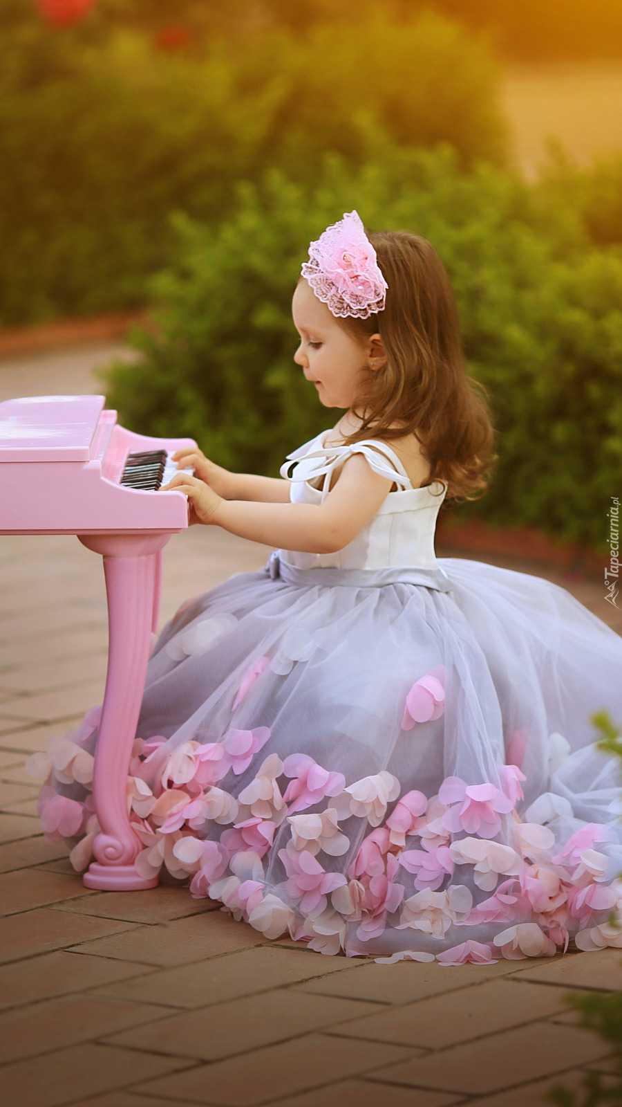 Dziewczynka przy różowym fortepianie