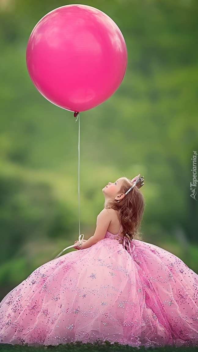 Dziewczynka w balowej sukni z balonikiem