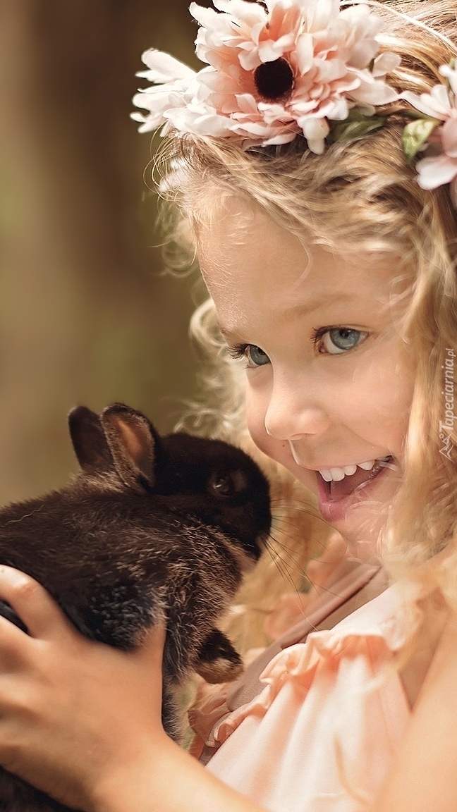 Dziewczynka w wianku z czarnym królikiem