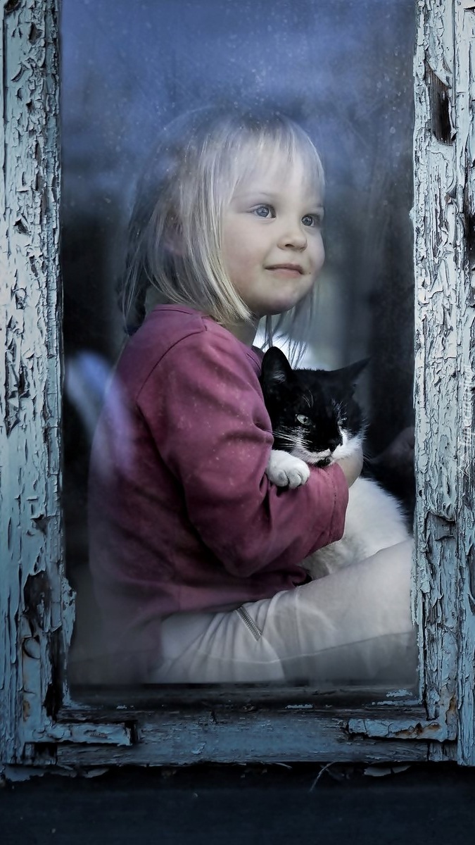 Dziewczynka z kotkiem w oknie