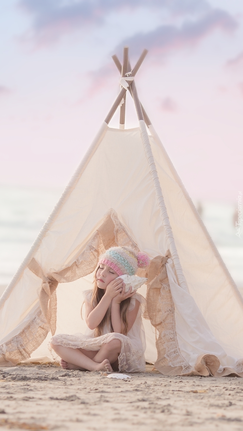 Dziewczynka z muszlą w namiocie na plaży