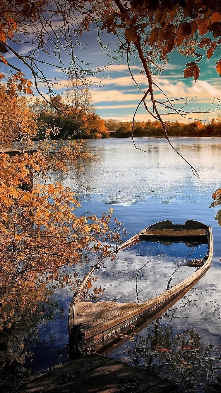 Dziurawa łódka na jesiennym jeziorze