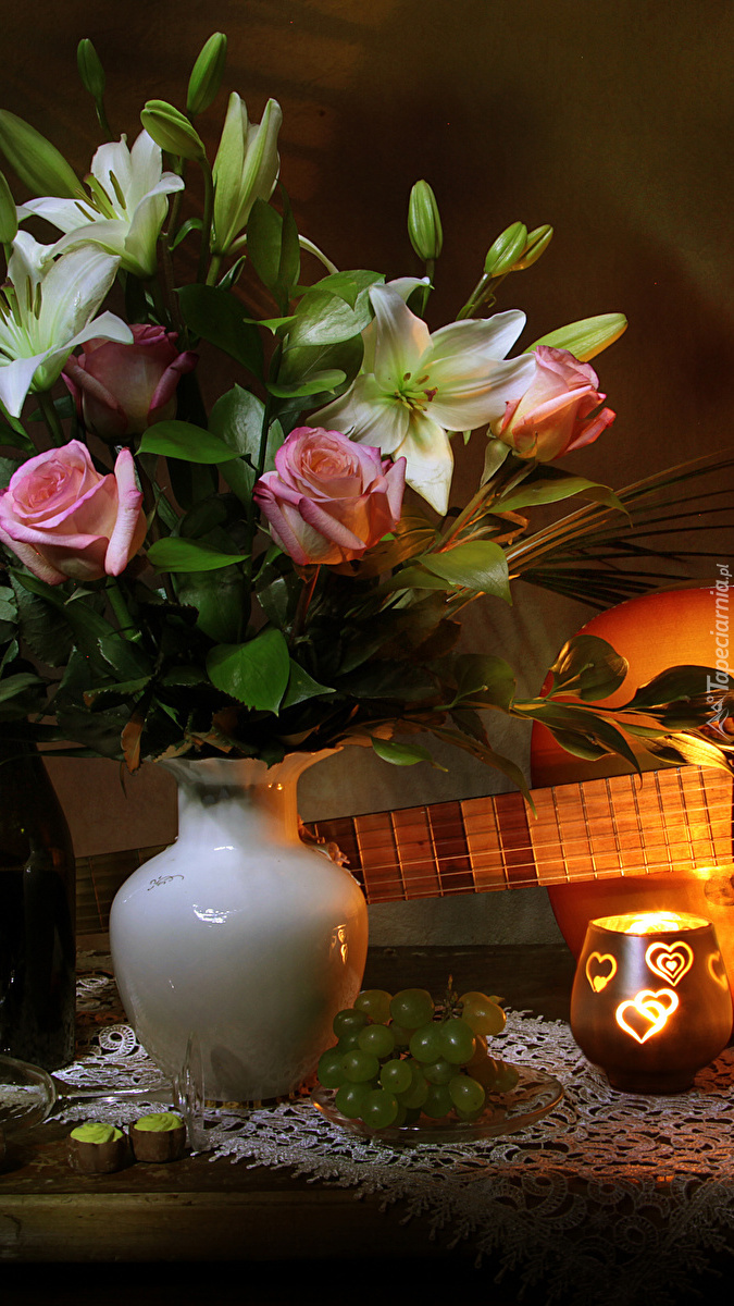 Gitara obok lilii i róż w wazonie