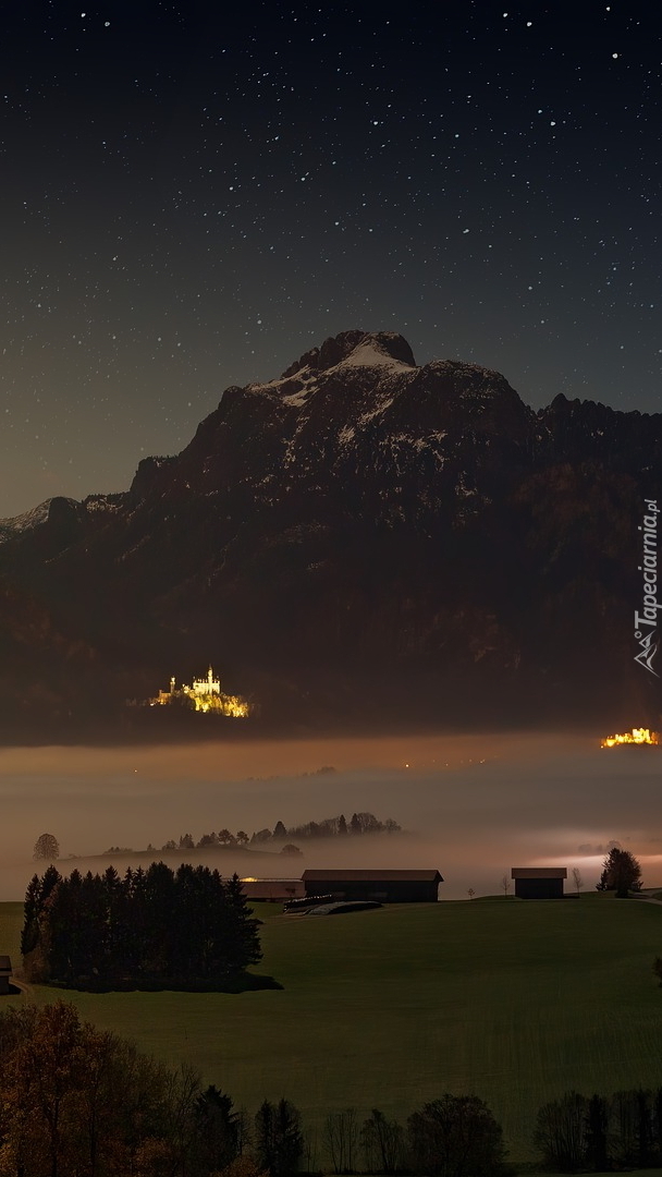 Gwiaździste niebo nad zamglonym jeziorem Forggensee