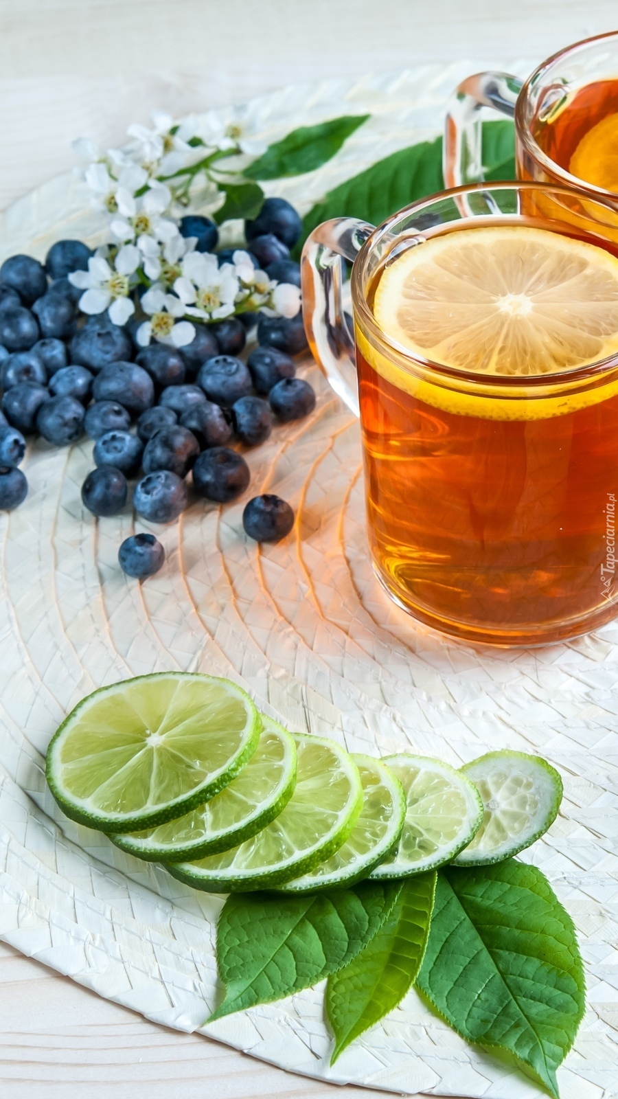 Herbata z cytryną obok jagód i limonki