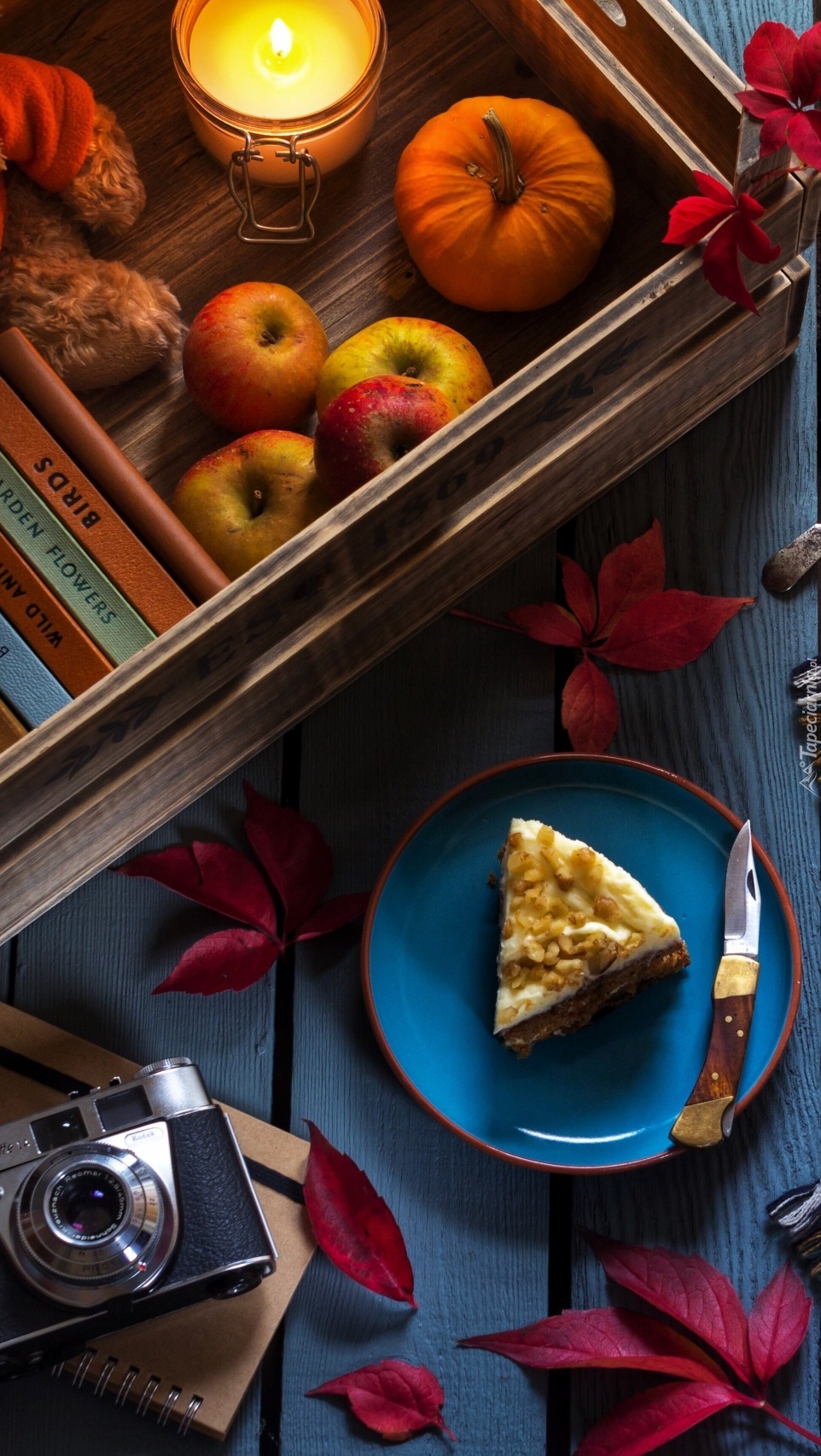 Jesienna kompozycja ze świeczką i słodkim ciastem na talerzu