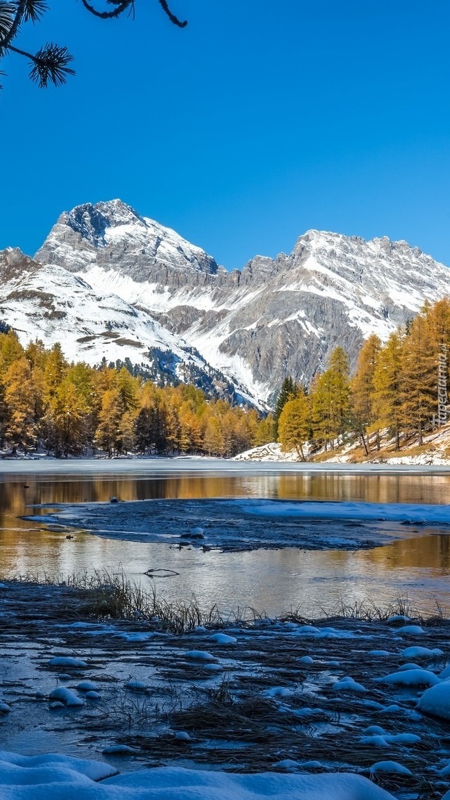 Jezioro zimą z widokiem na ośnieżone góry