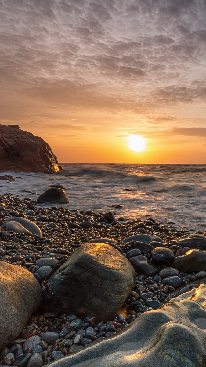 Kamienie na brzegu morza o zachodzie słońca