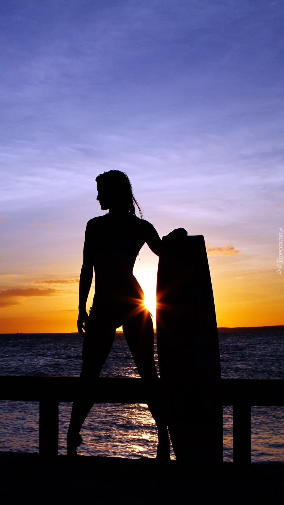 Kobieta nad morzem o zachodzie słońca