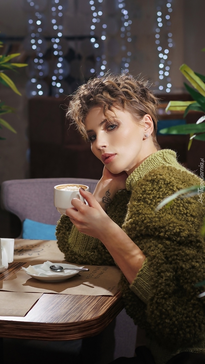 Kobieta przy kawiarnianym stoliku