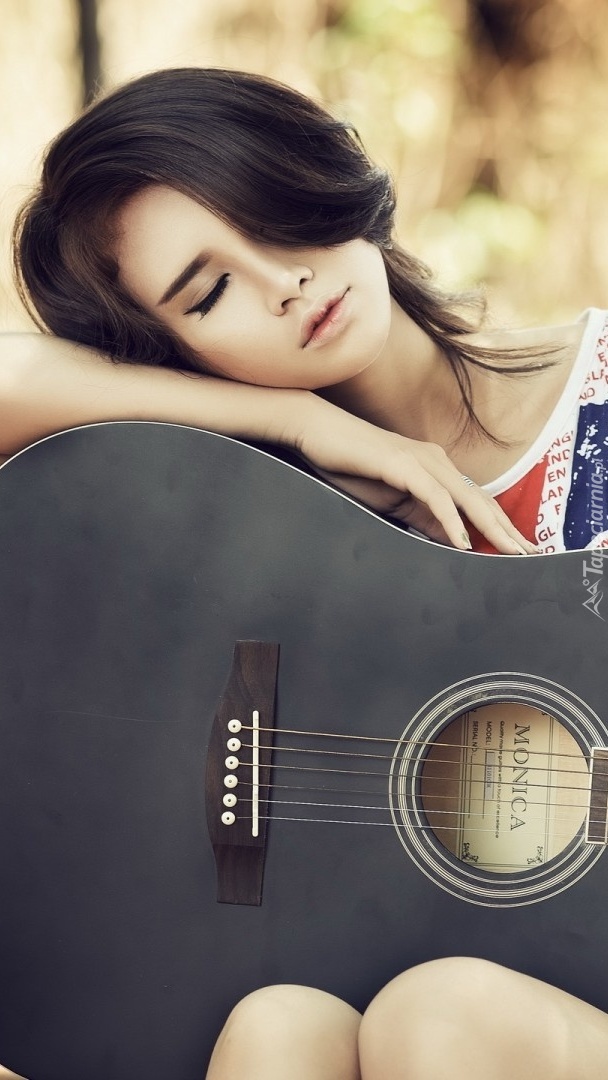 Kobieta śpiąca na gitarze