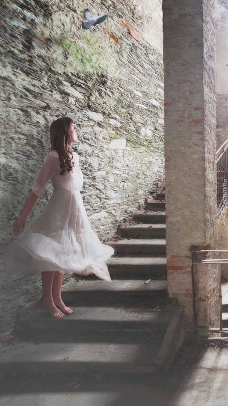 Kobieta w białej sukience na schodach