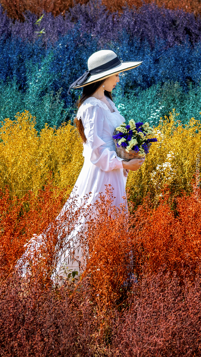 Kobieta w białej sukni wśród kolorowych roślin