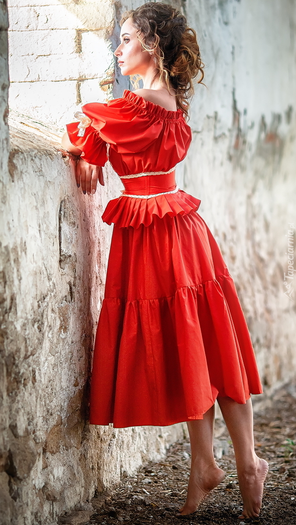 Kobieta w czerwonej sukience przy oknie