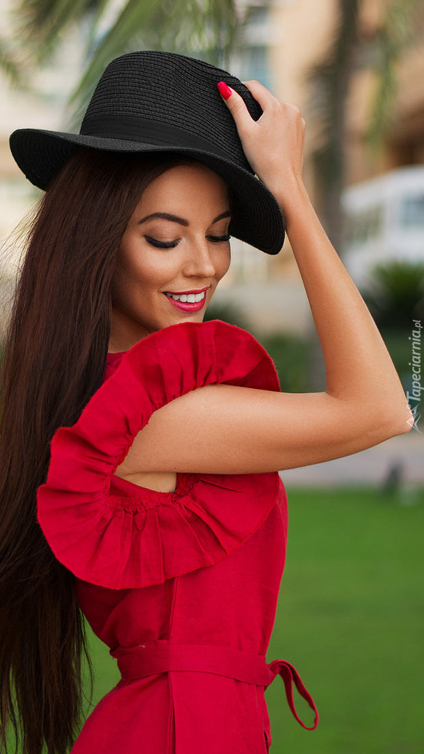 Kobieta w kapeluszu i czerwonej sukience