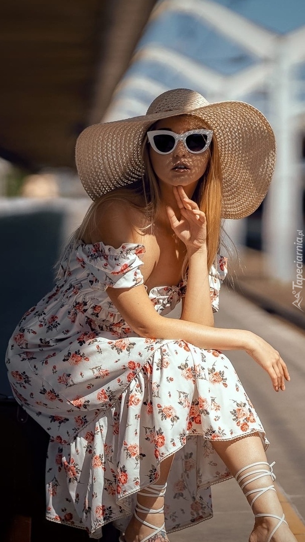 Kobieta w letniej sukience okularach i kapeluszu
