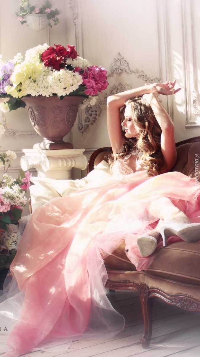 Kobieta w różowej sukni na sofie