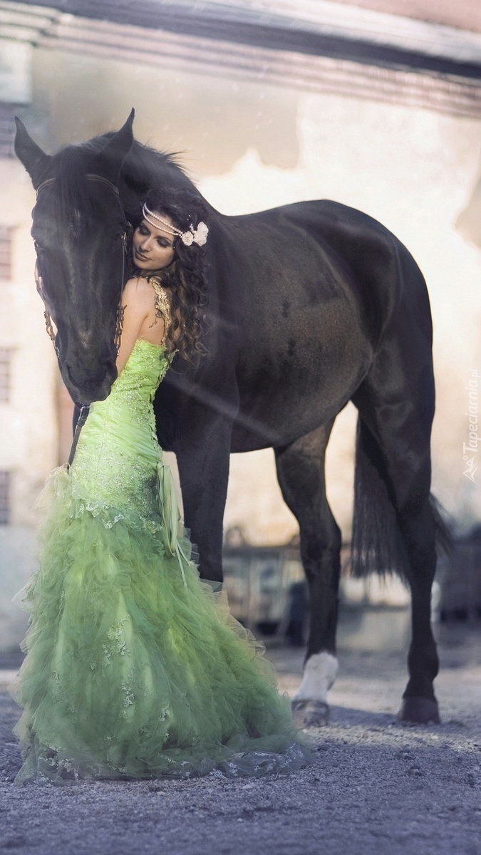 Kobieta w zielonej sukience tuli się do konia