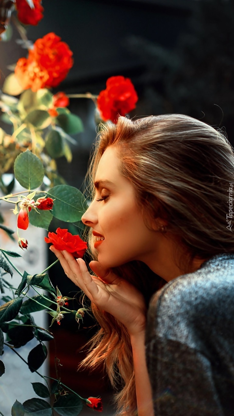 Kobieta wąchająca różę