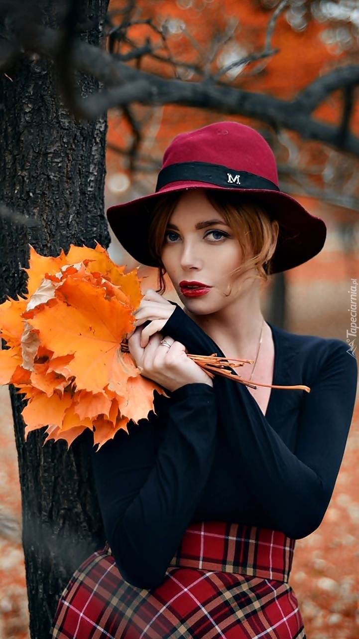 Kobieta z bukietem jesiennych liści