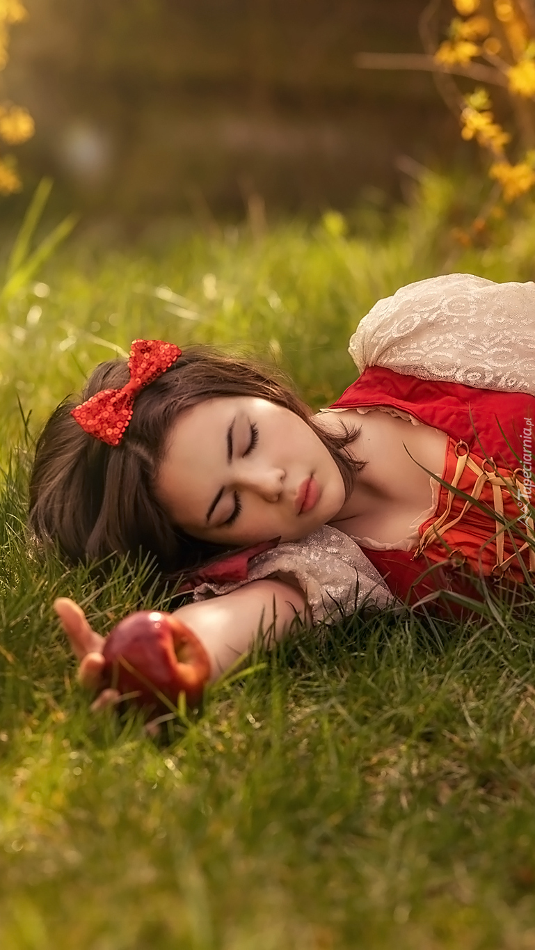 Kobieta z jabłkiem na trawie