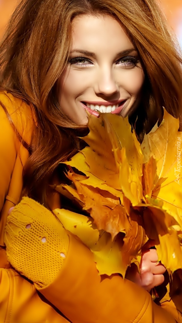 Kobieta z jesiennymi liśćmi klonu